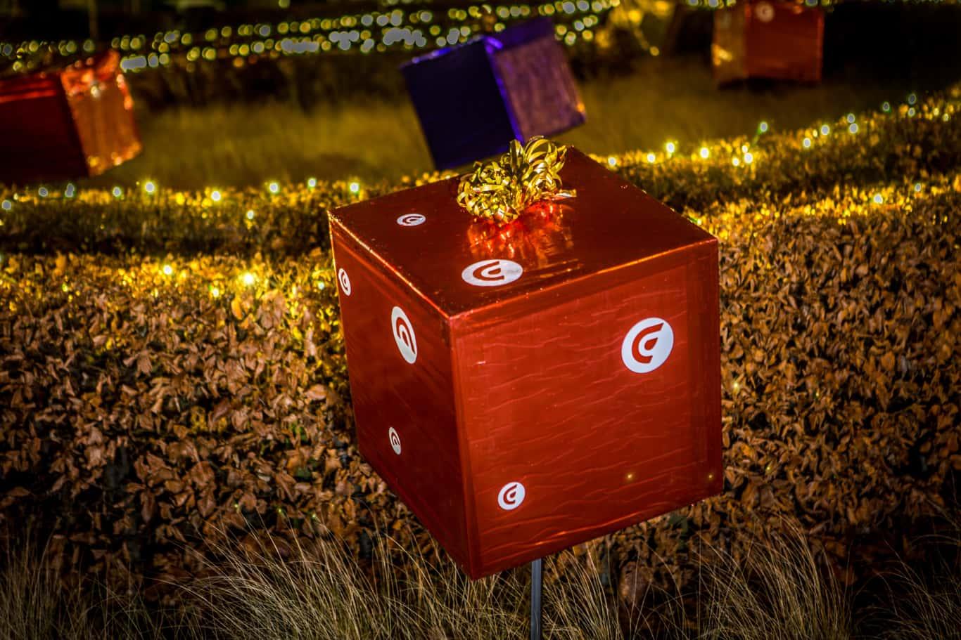 rode pakjes van Cofinimmo Kerstmis kwam dichterbij … en zo deden de pakjes ! Maar niet allemaal. Enkel de Cofinimmo rode pakjes. Om aan te tonen dat Cofinimmo naar zijn klanten toe komt, was het in het project zo voorzien dat de rode pakjes steeds dichter naar de verschillende hoofdingangen van de gebouwen verplaatst werden. Vlak voor de kerst stonden de pakjes dan binnenin de gebouwen waar ze de mensen opwachtten met een mooie kerstkaart (met uitleg over het concept). In de kerstkaart was er ook een reep muntjes aangebracht, 12 muntjes, voor elke maand van het nieuwe jaar een frisse start.
