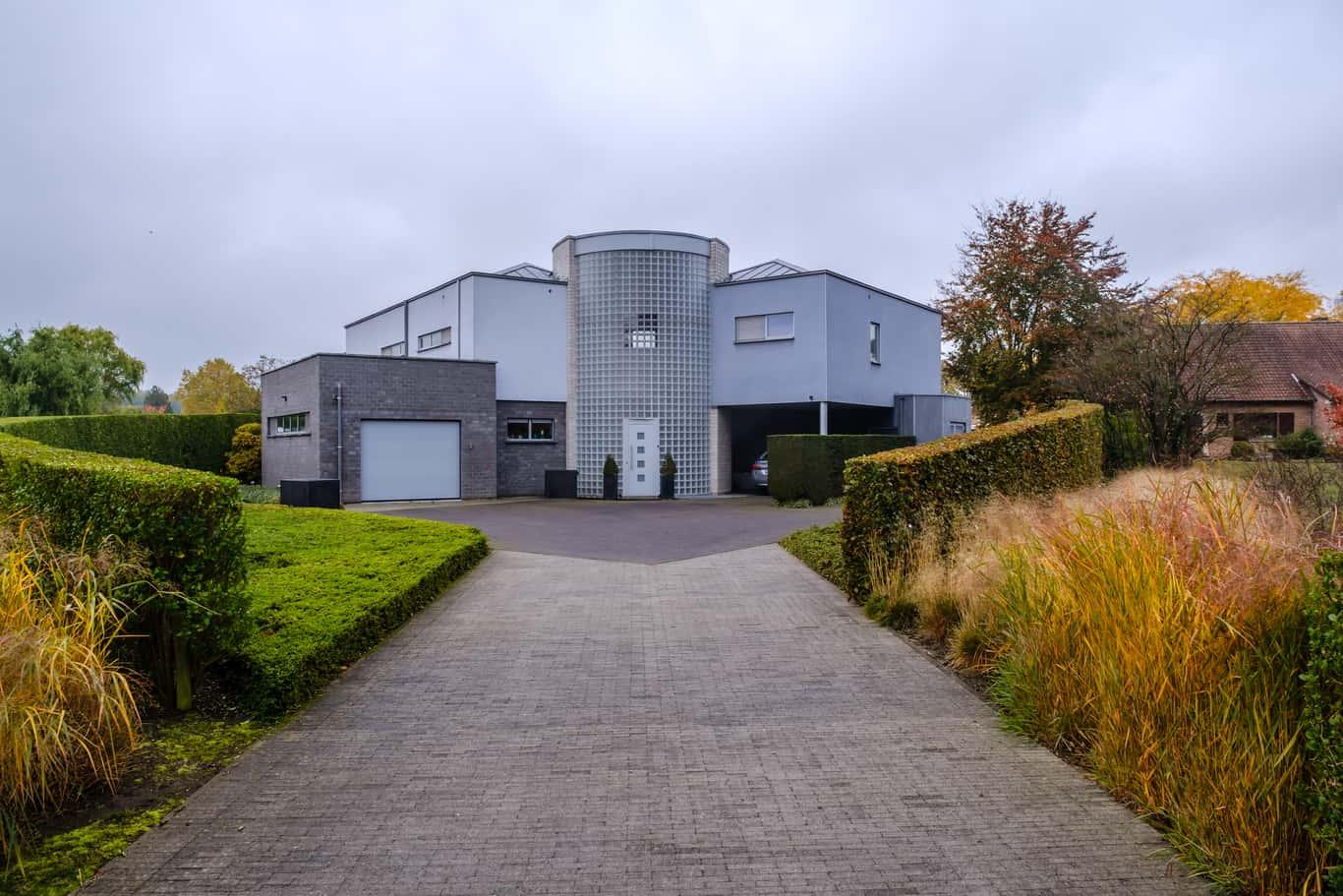 De speelse karakter van het huis doorgestrokken in de tuin met de blokken en de hagen het huis van Roeland een speels huis is, dat aan een stapel blokken laat denken.nIn de voortuin hebben we vierkante blokken als dobbelstenen uitgerold. Aan de laatste dobbelsteen stroomt er water aan de voordeur. De woning is een speelse opstelling van blokken. Er wordt spanning opgebouwd in de voortuin. De hagen zijn eerst laag maar worden groter en groter.