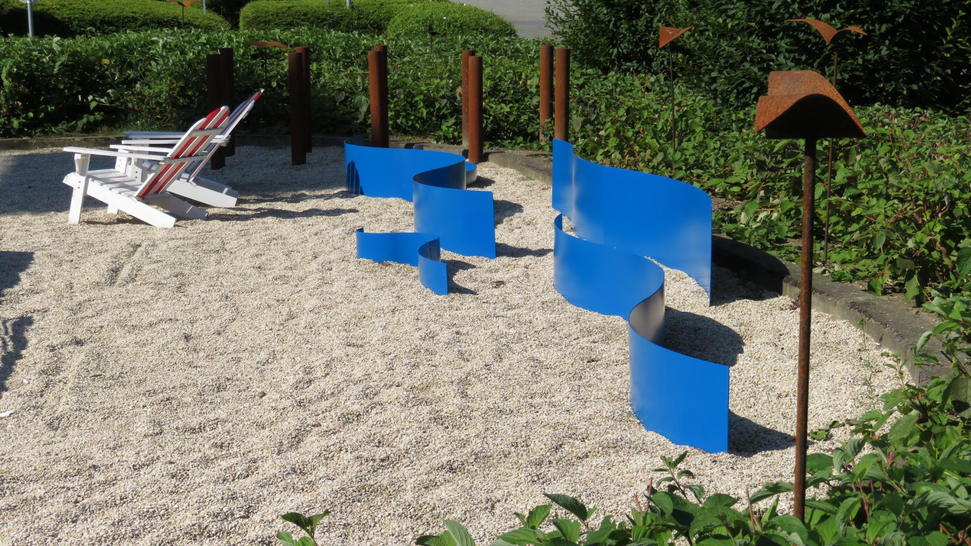 Met dit concept gaan we het buitenmeubilair in de sfeer ontwerpen van de kust. \nEr komen grote blauwen metalen golven, metalen meeuwen lijken te krijsen in de lucht. Een pauze op de Noordkustlaan roept dat vakantiegevoel eventjes terug.\n